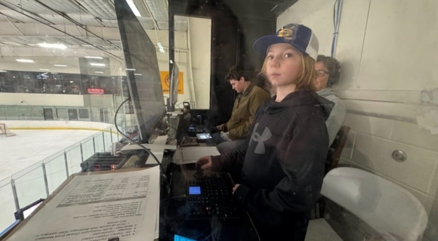 A young volunteer operates a PTZOptics SuperJoy Controller, while another volunteer operates the YoloBox.